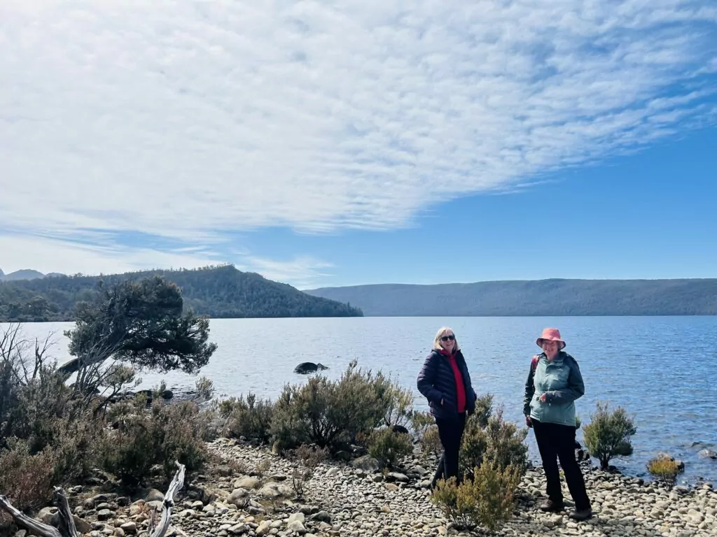 Two women stand on the shore of Lake St Clair